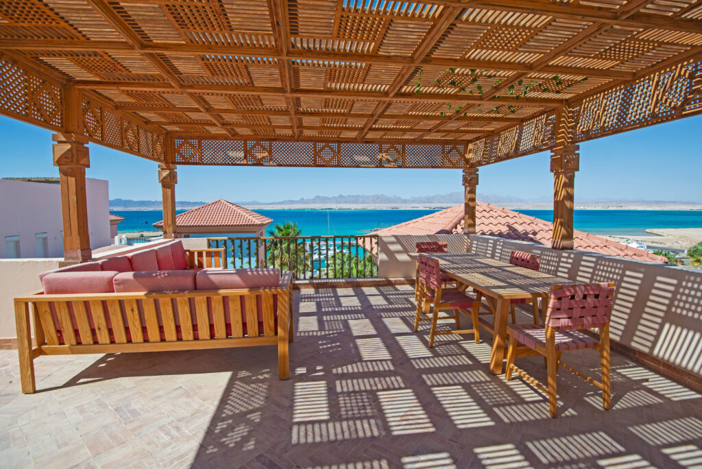 Pérgola en la terraza con sillas en una lujosa villa tropical de vacaciones en la Costa del Sol. Pergola in terrace patio with chairs in tropical luxury holiday villa in Costa del Sol. Pergola sur la terrasse avec des chaises dans une villa de vacances tropicale de luxe sur la Costa del Sol.