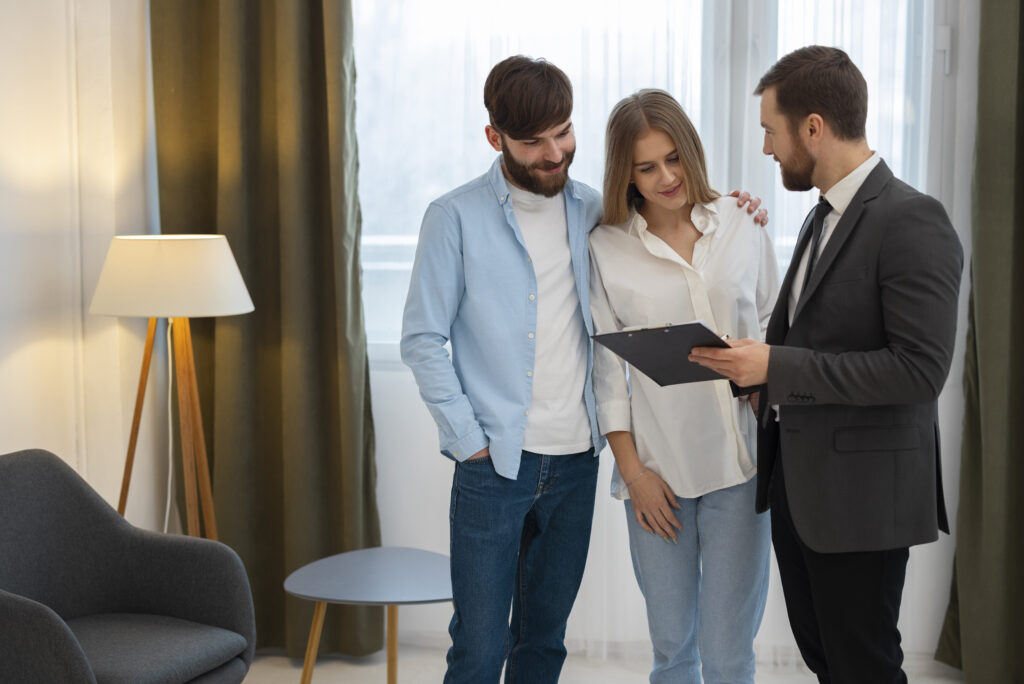Agente inmobiliario masculino haciendo negocios y mostrando la casa una posible pareja compradora